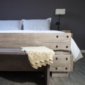 een slaapkamer met een bed met een houten voetplank bij Ca Veja B&B Forlì in Forlì