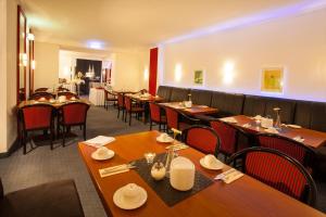 a dining room with wooden tables and chairs at Hansadom Hotel Köln Central by Mayburgh in Cologne
