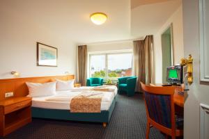 a hotel room with a bed and a television at Hansadom Hotel Köln Central by Mayburgh in Cologne