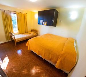 a bedroom with a bed and a television at Matices Hostel in El Calafate