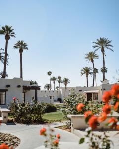 ein Gebäude mit Palmen und Blumen im Vordergrund in der Unterkunft The Wigwam in Litchfield Park