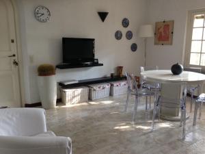 a living room with a table and chairs and a tv at Holiday home Villetta Cinquale in Cinquale