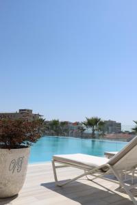 a white lounge chair sitting next to a swimming pool at Hotel Villa Pascucci in Durrës