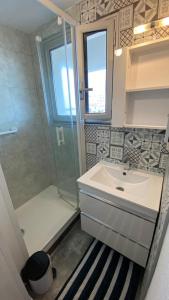 ein Bad mit einem Waschbecken und einer Dusche in der Unterkunft RETOUR AUX SOURCES in Royan