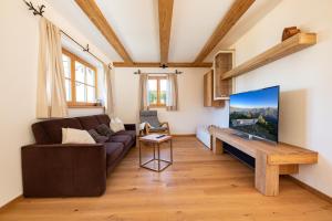 a living room with a couch and a flat screen tv at am Josefibrunnen in Farchant