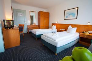 a hotel room with two beds and a television at INA Hotel Royal in Cologne