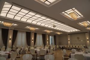 a banquet hall with white tables and chairs at Hotel Villa Pascucci in Durrës