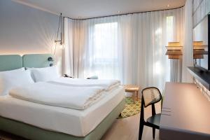 A bed or beds in a room at Hotel Indigo Vienna - Naschmarkt, an IHG Hotel
