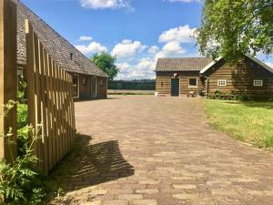 a brick driveway in front of a house and a fence at vakantiewoning Bovenhaar in Punthorst