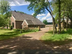 an old house with a fence and a driveway at vakantiewoning Bovenhaar in Punthorst