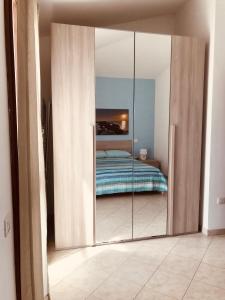 - une chambre avec un placard miroir et un lit dans l'établissement casaDAmare, à Pula