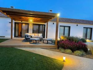 a backyard with a patio with a wooden pergola at Quinta do Planalto Vicentino - Casas de Campo in Aljezur