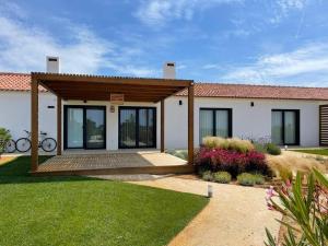 a white house with a porch and a garden at Quinta do Planalto Vicentino - Casas de Campo in Aljezur