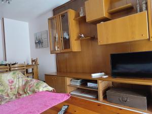 - un salon avec une télévision et des placards en bois dans l'établissement Apartamentos Casa May III - Centro Benidorm, à Benidorm