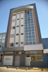 a tall white building with a lot of windows at Boa Esperança Apart Hotel in Boa Esperança