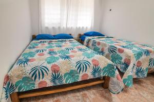 two beds sitting next to each other in a bedroom at Hermosa Cabana con Piscina 3 Habitaciones MC21 in Coveñitas