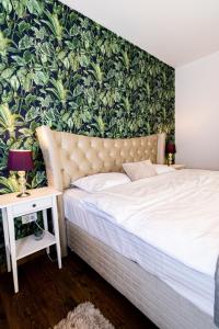 a bedroom with a bed with a tropical wallpaper at Nature Apartment - Minutes Away from the Old Town and AFI Mall in Braşov