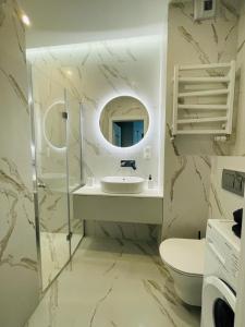 a bathroom with a sink and a mirror at Apartamenty Plaza Tower in Kielce