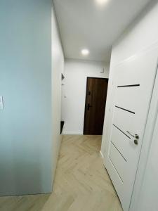 une chambre vide avec une porte blanche et un couloir dans l'établissement Apartamenty Plaza Tower, à Kielce