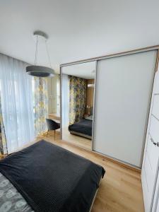 sypialnia z dużym lustrem obok łóżka w obiekcie Apartamenty Plaza Tower w Kielcach