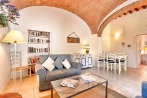 salon z kanapą i stołem w obiekcie Appartamenti Villa La Fonte w mieście San Gimignano