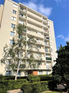 a tall building with a tree in front of it at BROSSOLETTE Appartement T2 spacieux et lumineux balcon vue dégagée in Reims