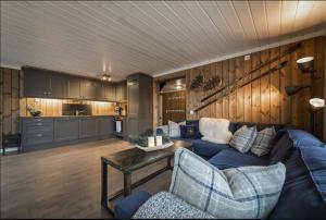 a living room with a blue couch and a kitchen at Cabin with sauna in Trysil in Trysil