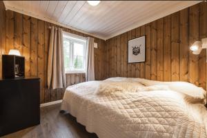 a bedroom with wooden walls and a bed in a room at Cabin with sauna in Trysil in Trysil