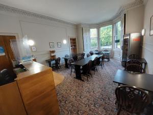 a dining room with tables and chairs and windows at Edinburgh House Hotel in Edinburgh