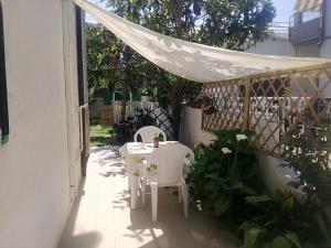 a table and chairs on a patio with a white canopy at Goccia Azzurra in Silvi Marina +14 photos