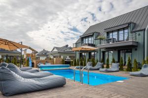 a backyard with a swimming pool and a house at Green Shine Apartment, By Cohost in Palanga