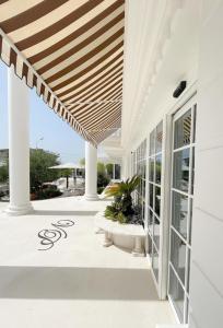 a porch of a white house with a wooden ceiling at Hotel Villa Pascucci in Durrës