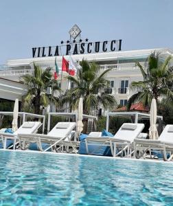 a swimming pool with lounge chairs and a hotel at Hotel Villa Pascucci in Durrës