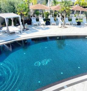 a swimming pool with chairs and umbrellas at Hotel Villa Pascucci in Durrës