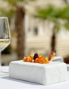 a plate of food next to a glass of wine at Hotel Villa Pascucci in Durrës