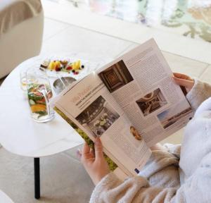 uma pessoa está lendo um livro ao lado de uma mesa em Hotel Villa Pascucci em Durrës