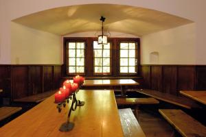 Mariastein-Rotberg Youth Hostel في Mariastein: غرفة مع طاولة طويلة مع شموع حمراء عليها