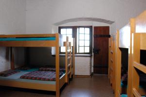 a room with three bunk beds and a window at Mariastein-Rotberg Youth Hostel in Mariastein