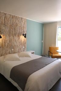 a bedroom with a large bed with a wall at Les Alcyons in Le Lavandou