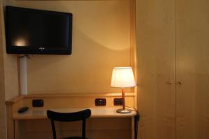 a room with a desk with a lamp and a television at Sant'Ambroeus in Milan