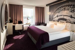 ein Hotelzimmer mit einem großen Bett und einem Schreibtisch in der Unterkunft Dorint Kongresshotel Mannheim in Mannheim