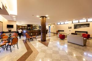 a lobby with a table and chairs and a couch at Blue Relais Maggiore in Castelletto sopra Ticino