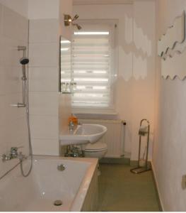 ein Badezimmer mit einer Badewanne, einem Waschbecken und einem WC in der Unterkunft Ferienwohnung Zierold in Zwenkau