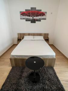 een bed met een zwarte kruk in een kamer bij Militari Studio in Roşu