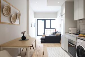 uma cozinha e sala de estar com uma mesa e um sofá em FLORIT FLATS - The Serreria Rooms em Valência