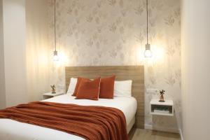 um quarto com uma cama grande e almofadas laranja em FLORIT FLATS - The Serreria Rooms em Valência