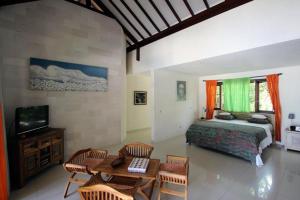 um quarto com uma cama, uma mesa e cadeiras em Frangipani Beach Hotel em Lovina
