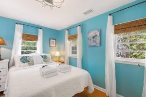 a blue bedroom with a white bed and a window at 817 E Ashely Ave Pleasant Breeze in Folly Beach