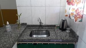 a kitchen counter with a stainless steel sink at Floripa Surf Hostel in Florianópolis