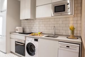 a kitchen with a washing machine and a microwave at CASA FLORIT - The Maritim Serreria Suites in Valencia